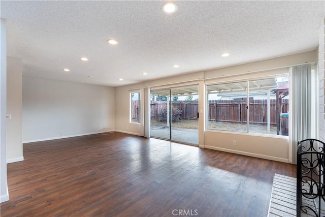 spare room featuring dark hardwood / wood-style flooring and a textured ceiling