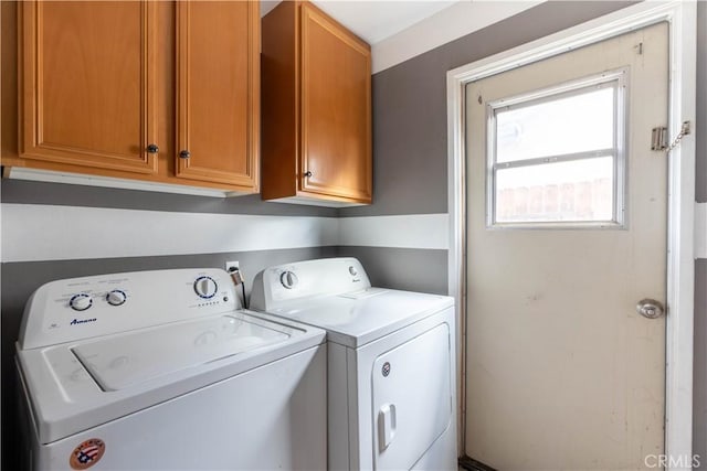 washroom featuring cabinets and washer and clothes dryer