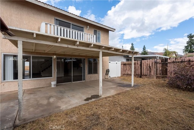 back of property with a patio area and a balcony