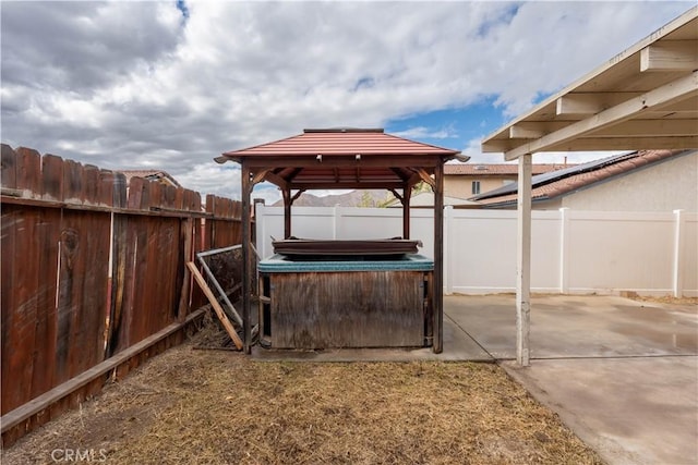 view of patio / terrace with a hot tub and a gazebo