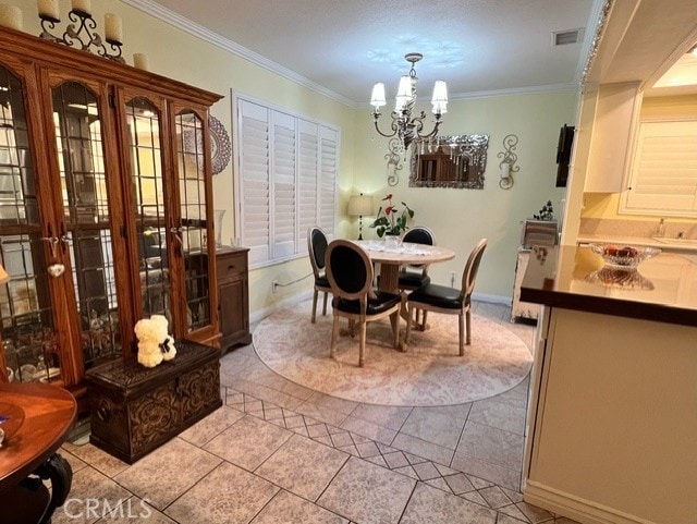 dining area with a notable chandelier, ornamental molding, and light tile patterned flooring