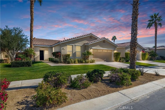 mediterranean / spanish-style home featuring a garage and a lawn