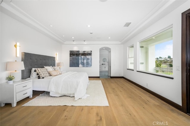 bedroom with crown molding and light hardwood / wood-style flooring