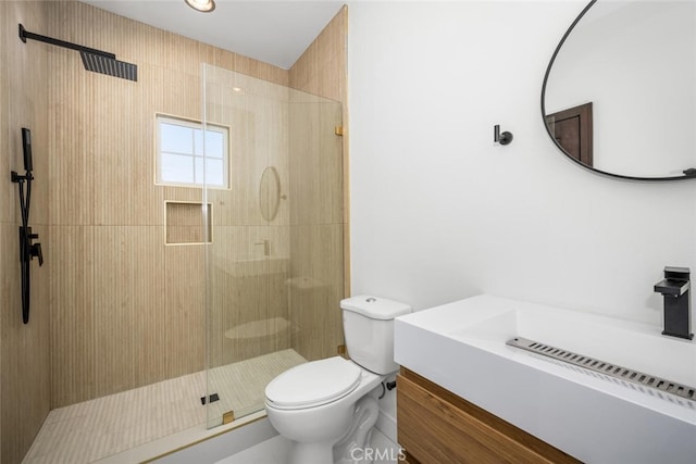 bathroom with vanity, a shower with shower door, and toilet