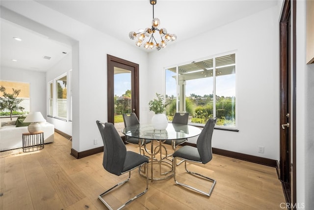 dining space featuring an inviting chandelier and light hardwood / wood-style flooring