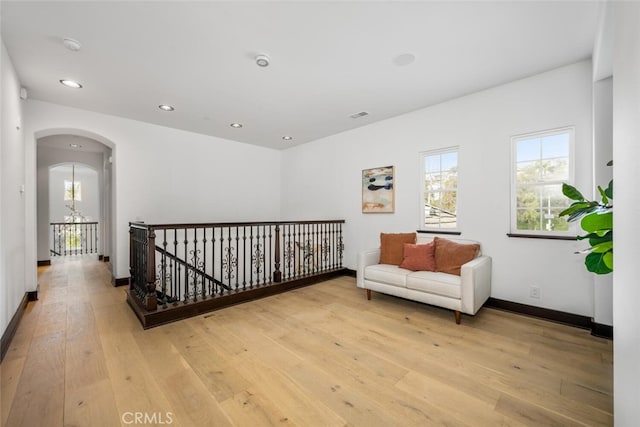 living area with an inviting chandelier and light wood-type flooring