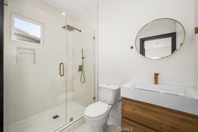 bathroom featuring vanity, toilet, and an enclosed shower