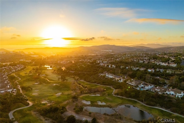 aerial view at dusk featuring a water and mountain view