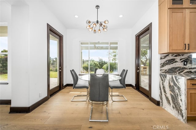 dining room with an inviting chandelier, light hardwood / wood-style floors, and a wealth of natural light