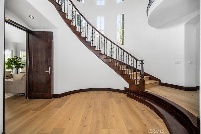 stairs featuring hardwood / wood-style flooring and a towering ceiling