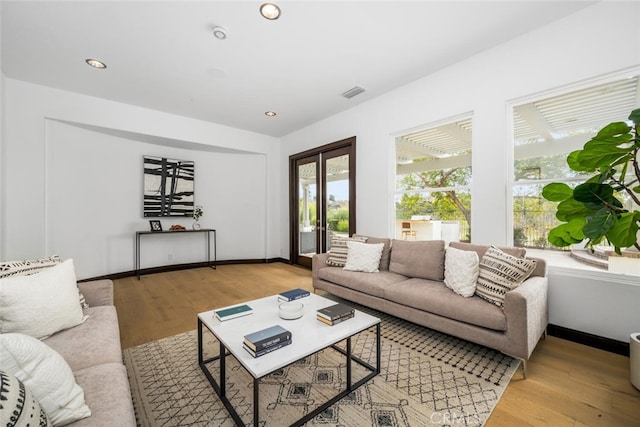 living room with french doors and light wood-type flooring