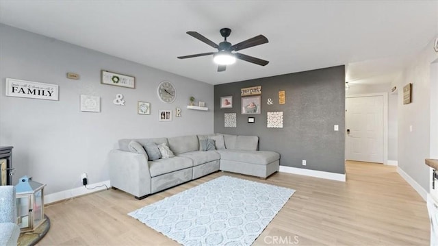 living room featuring ceiling fan and light hardwood / wood-style flooring