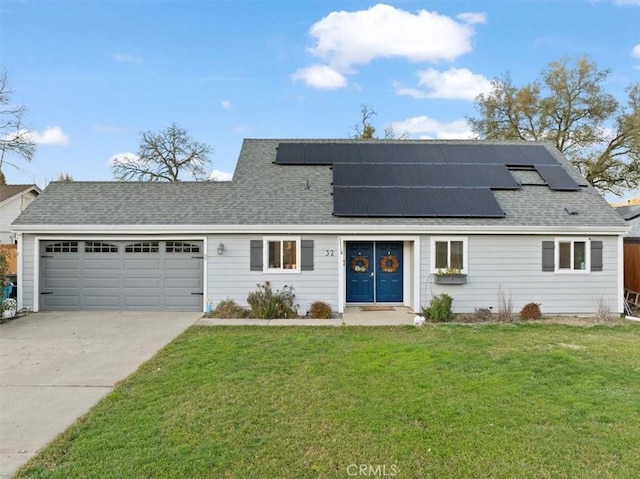 front of property with a garage, a front lawn, and solar panels