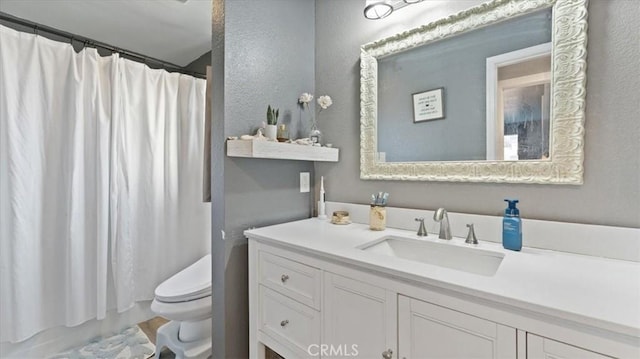 bathroom featuring walk in shower, vanity, and toilet