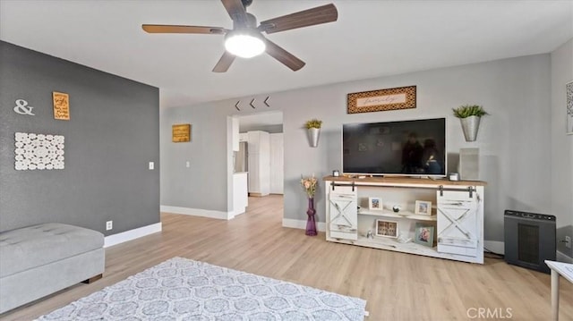 living room featuring ceiling fan and light hardwood / wood-style floors