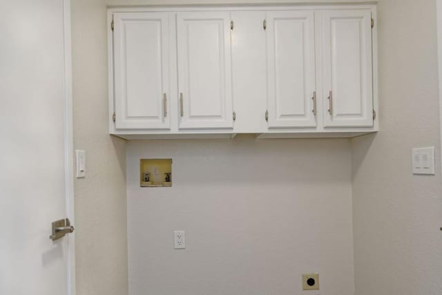 clothes washing area with washer hookup, cabinets, and electric dryer hookup