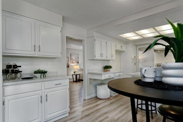 kitchen with white cabinetry and light hardwood / wood-style flooring