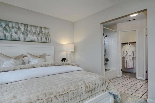 bedroom featuring light tile patterned flooring, a walk in closet, and a closet