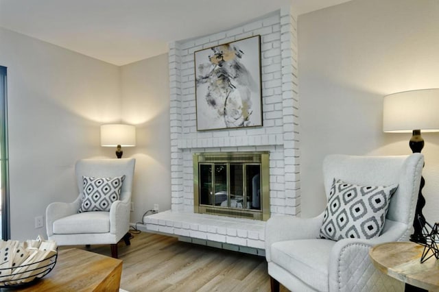 living area with a fireplace and light hardwood / wood-style floors