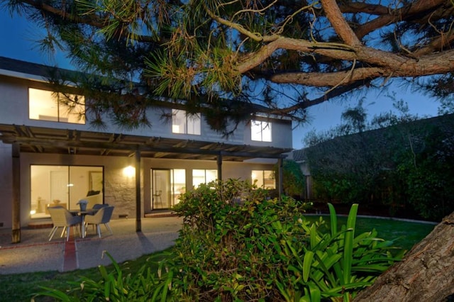 back of property featuring a pergola and a patio