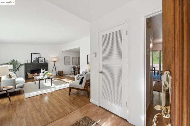 living room with a brick fireplace and light hardwood / wood-style flooring