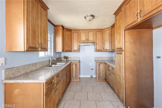 kitchen with sink, light tile patterned floors, and light stone countertops