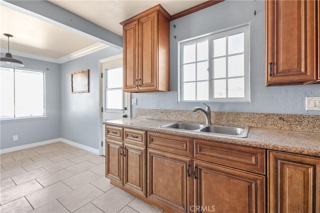 kitchen with pendant lighting, sink, crown molding, and light tile patterned floors