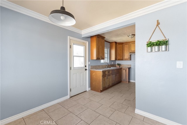 kitchen with crown molding, sink, and light tile patterned floors