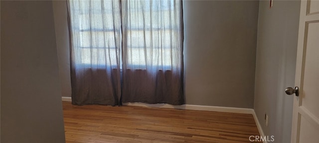 spare room with wood finished floors and baseboards