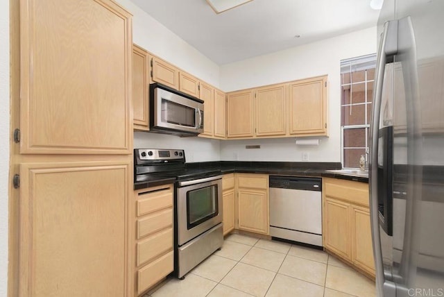 kitchen with stainless steel appliances, light brown cabinetry, sink, and light tile patterned floors