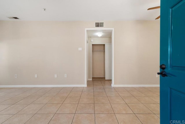 tiled empty room with ceiling fan