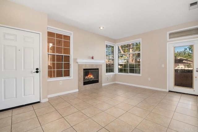 unfurnished living room with light tile patterned floors and a fireplace