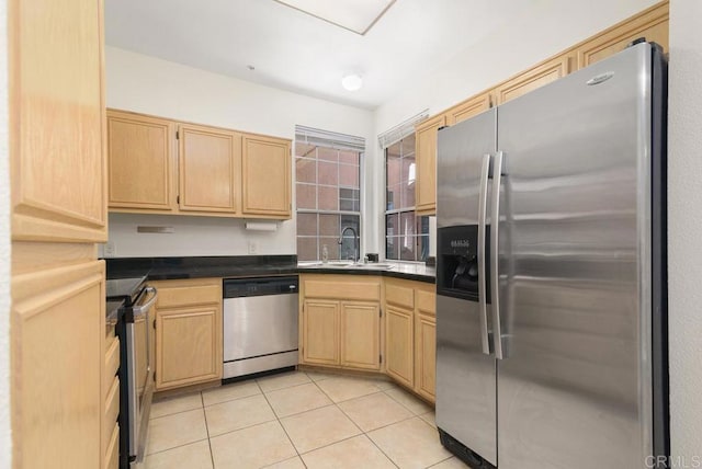 kitchen with stainless steel appliances, light brown cabinetry, sink, and light tile patterned floors