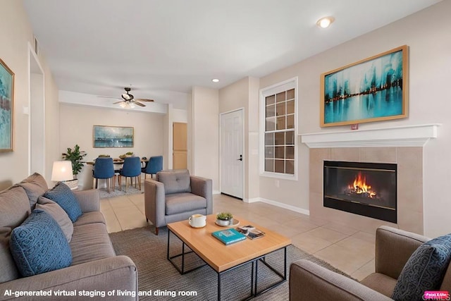 living room with ceiling fan, a tiled fireplace, and light tile patterned floors