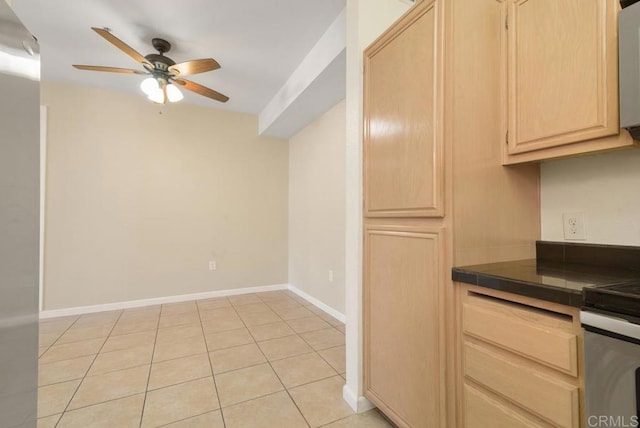 kitchen with light tile patterned flooring, light brown cabinetry, stove, tile counters, and ceiling fan