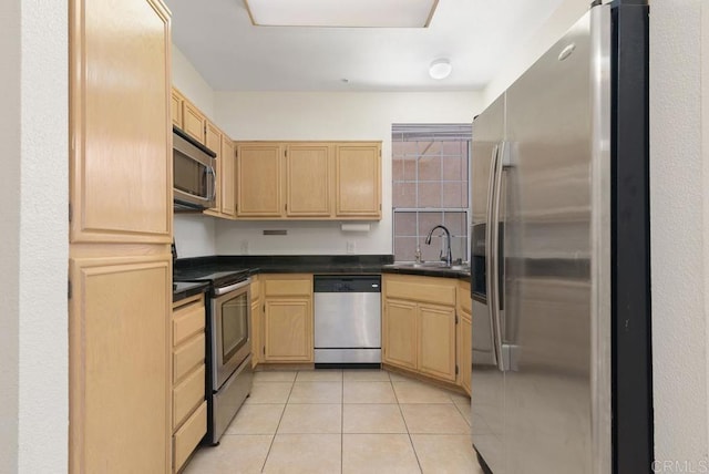 kitchen with appliances with stainless steel finishes, sink, light brown cabinets, and light tile patterned floors