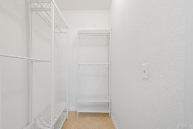 walk in closet with light tile patterned floors