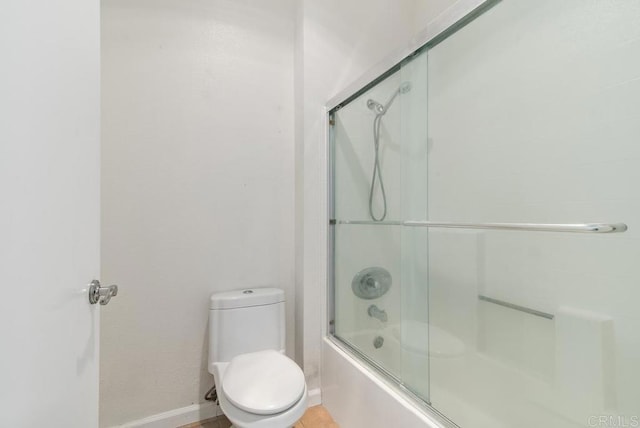 bathroom featuring enclosed tub / shower combo and toilet