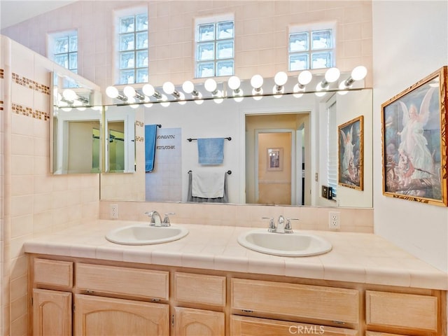 full bathroom with a sink and double vanity