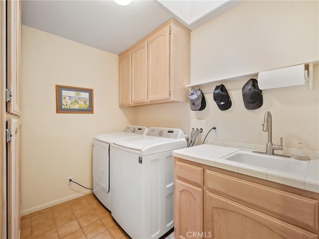 laundry room with light tile patterned flooring, a sink, baseboards, cabinet space, and washing machine and clothes dryer