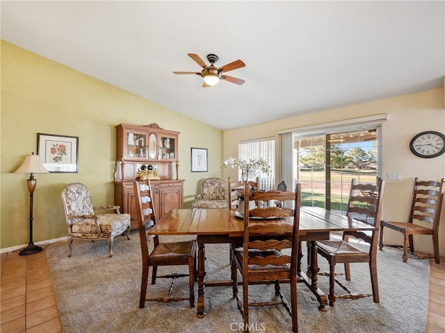 dining room featuring light tile patterned floors, ceiling fan, baseboards, and vaulted ceiling