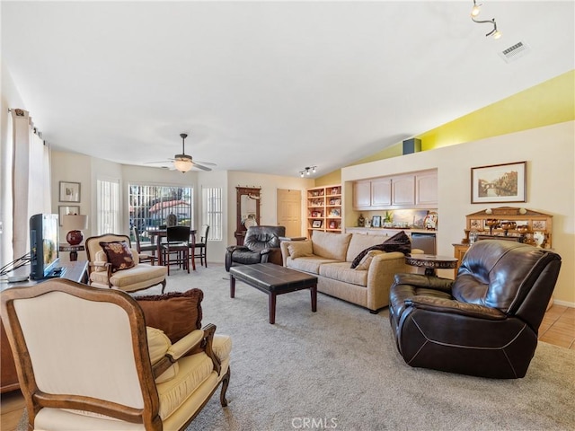 living area featuring light colored carpet, vaulted ceiling, visible vents, and ceiling fan