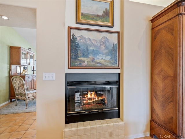 details with a glass covered fireplace and baseboards