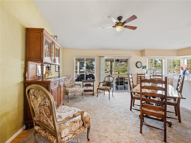 dining room with light carpet, a wealth of natural light, and baseboards