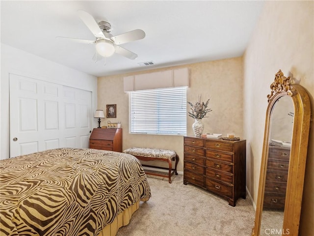 bedroom featuring a closet, light colored carpet, visible vents, a ceiling fan, and baseboards