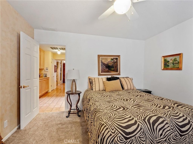 bedroom featuring light tile patterned floors, a ceiling fan, visible vents, and light colored carpet