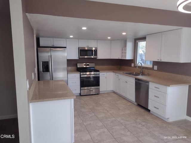 kitchen featuring sink, stainless steel appliances, light stone countertops, white cabinets, and light tile patterned flooring