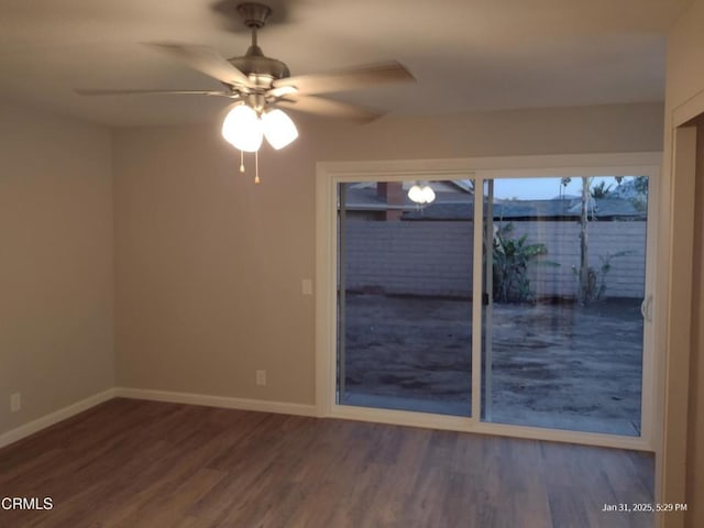 empty room with a ceiling fan, baseboards, and wood finished floors