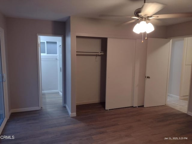 unfurnished bedroom featuring ceiling fan, a closet, wood finished floors, and baseboards