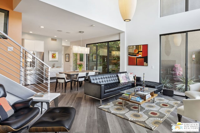 living room featuring a towering ceiling and wood-type flooring